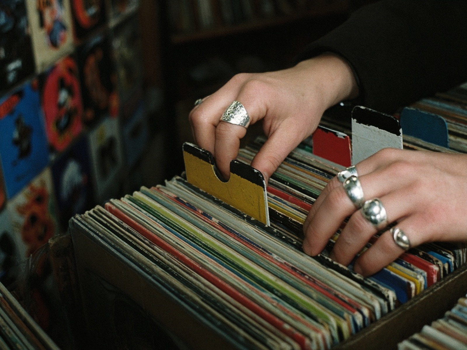 Hands flipping through vinyl records in a crate